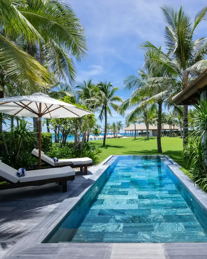Hồ bơi riêng của villa giữa vườn nhiệt đới, ghế tắm nắng bên cạnh